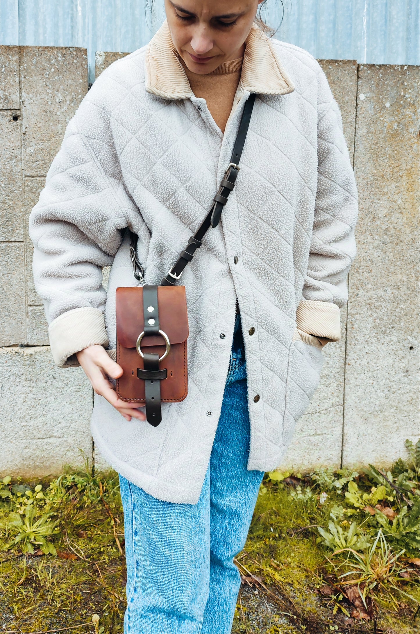 La couleur marron foncé est intemporelle et se marie avec toutes les tenues, tandis que la fermeture en anneau nickelé et la bandoulière en paire de rêne ajoutent une touche d'originalité.