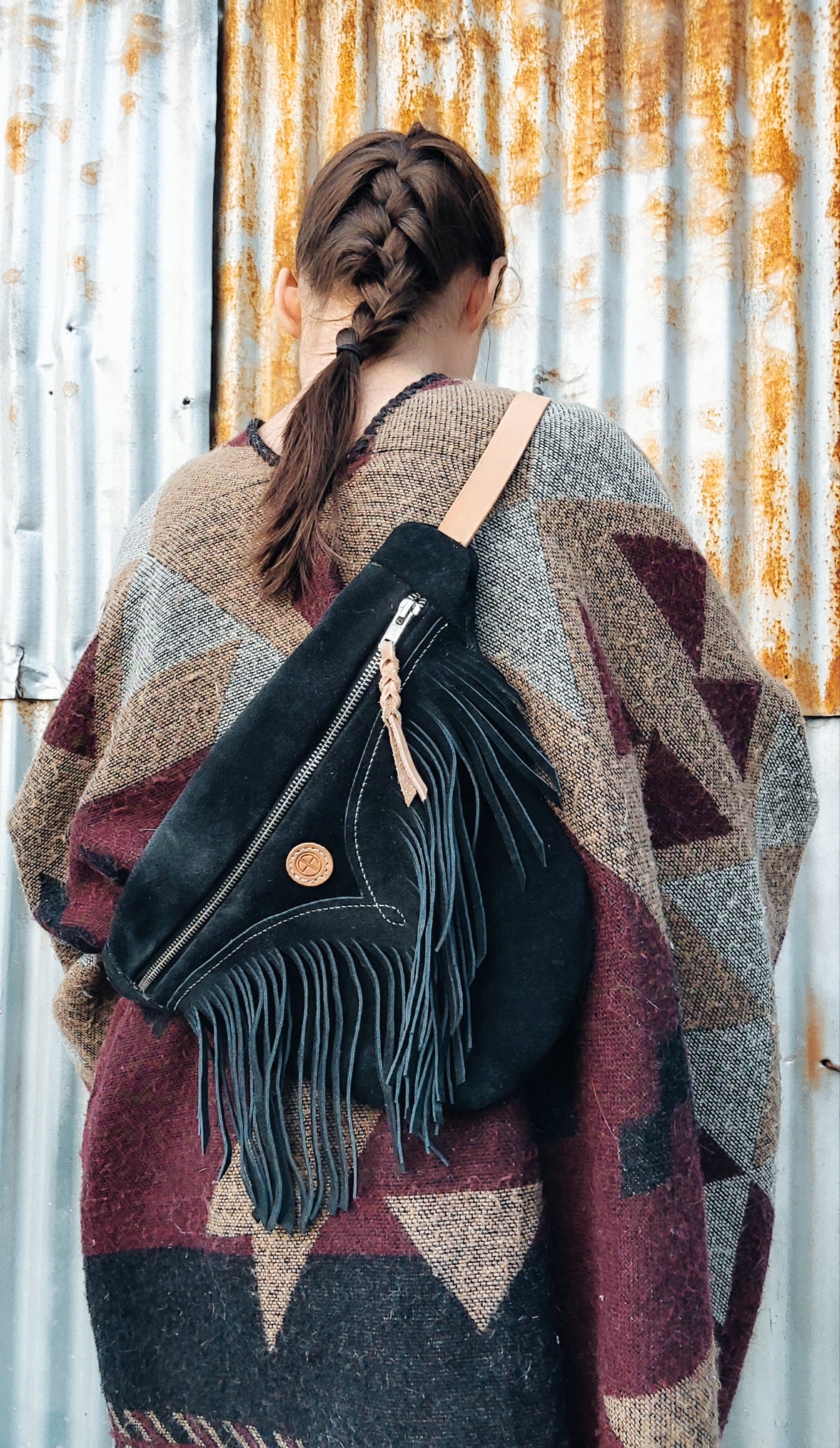 Femme à tresse portant une banane à franges au style vintage et cowboy.