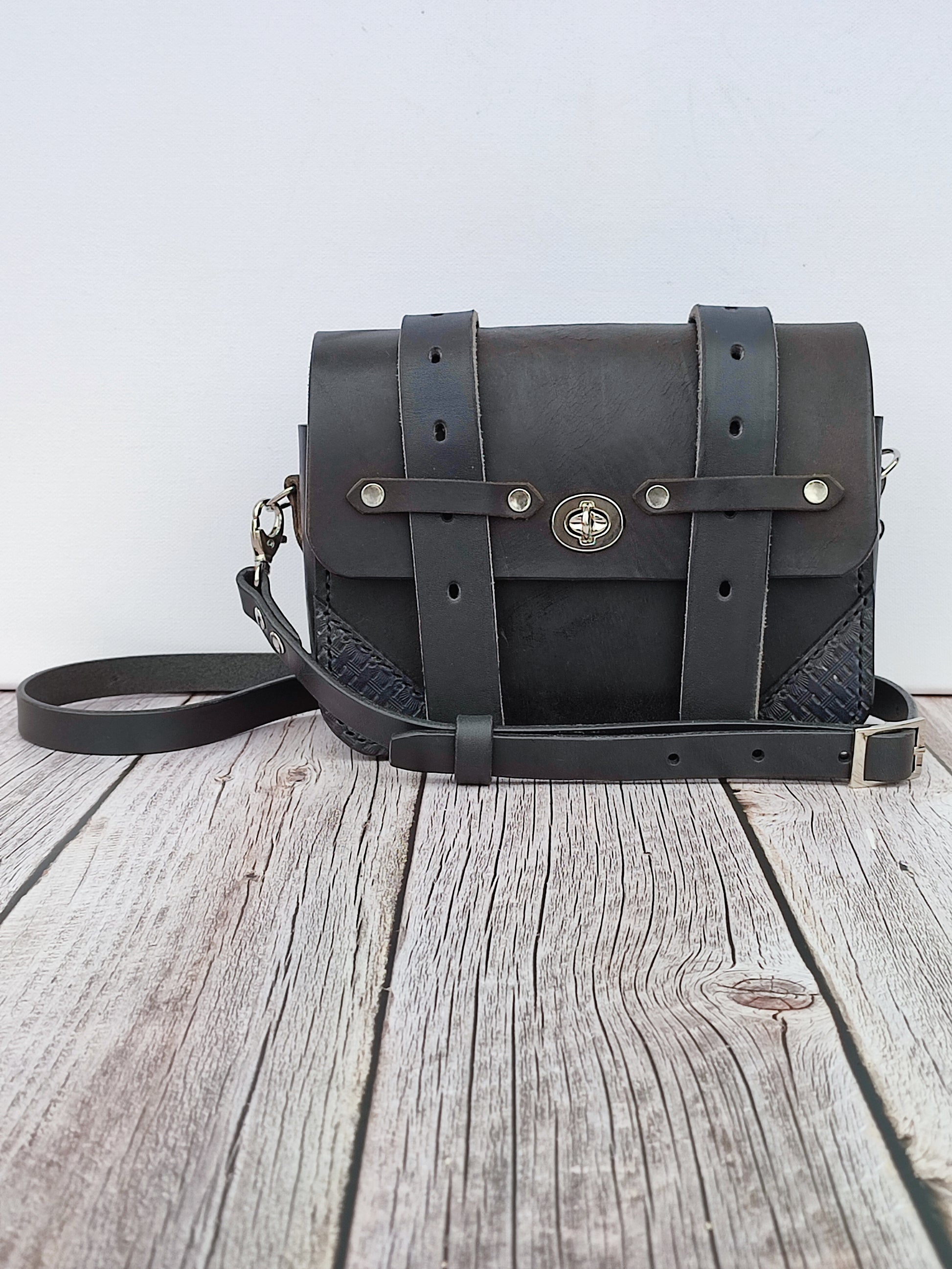 Le sac Besace noire est noir avec une bouclerie nickelée. Les détails en cuir repoussé lui donne un style western, cow girl chic.
