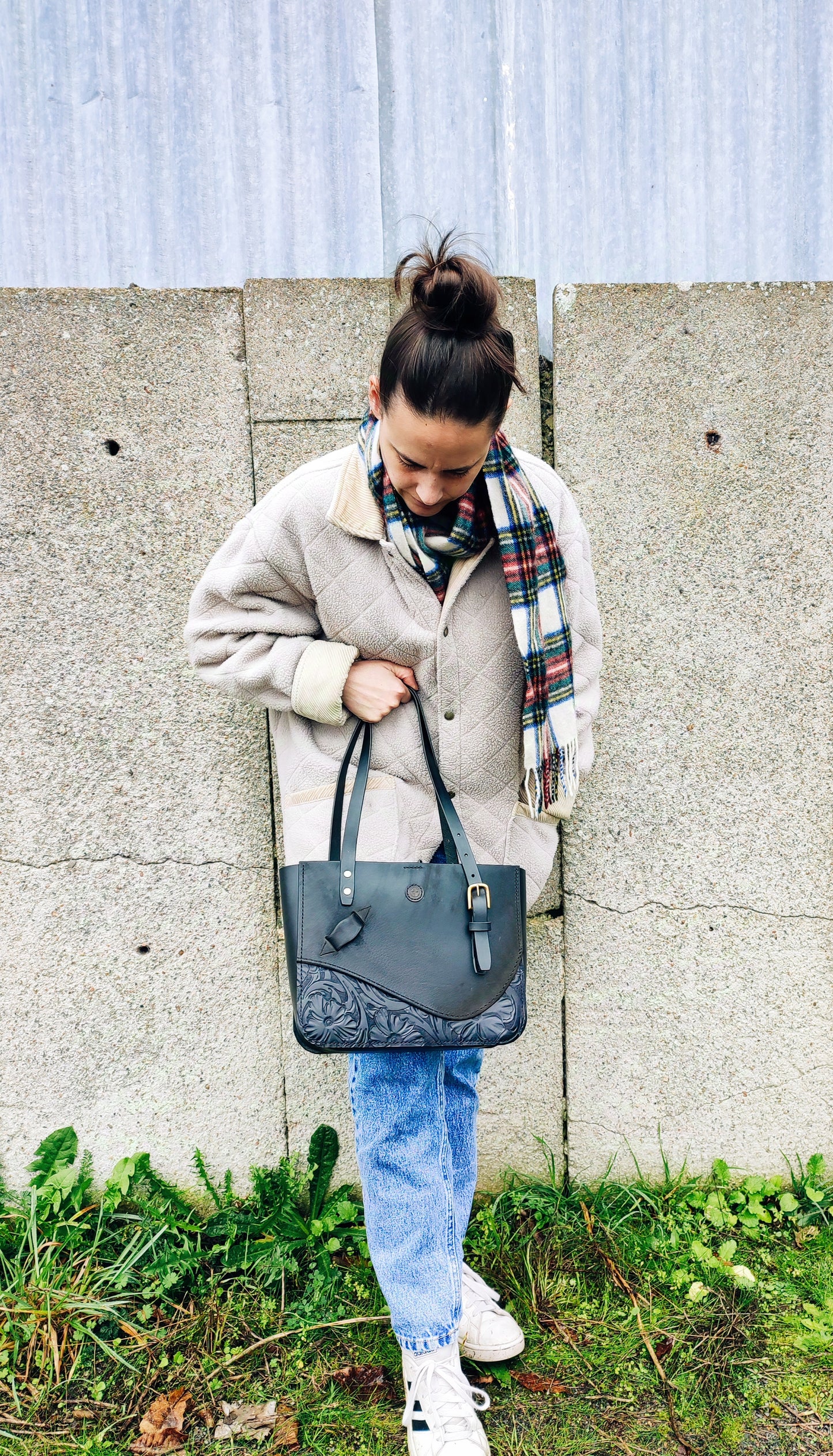 Le sac en cuir de selle d'équitation est porté par une femme au style english country side. Un sac chic et passe-partout.